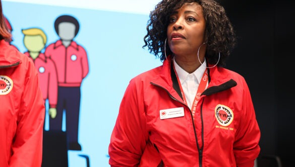 Staff member Sharon Webley in a red jacket speaking