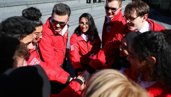 Volunteer mentors standing in a circle putting their hands in the middle for a spirit break