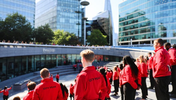 Volunteer mentors in red jackets on the steps of London's City Hall