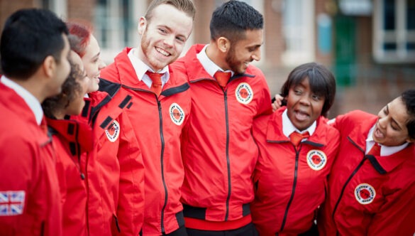 Group of volunteer mentors in uniform with their arms around each other smiling