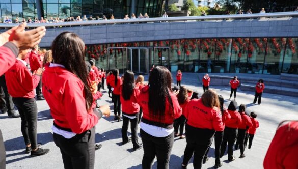 Volunteer mentors in red jackets on the steps of City Hall in London on Opening Day