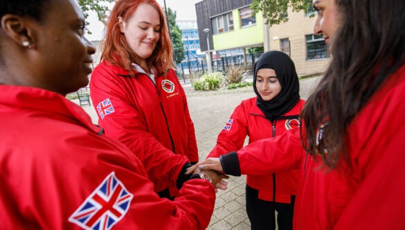 Volunteer mentors putting their hands in for a spirit break