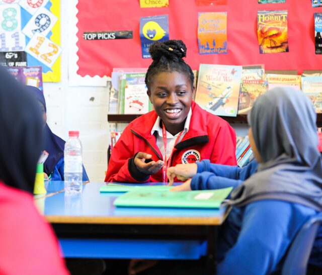 Volunteer mentor in classroom with a pupil