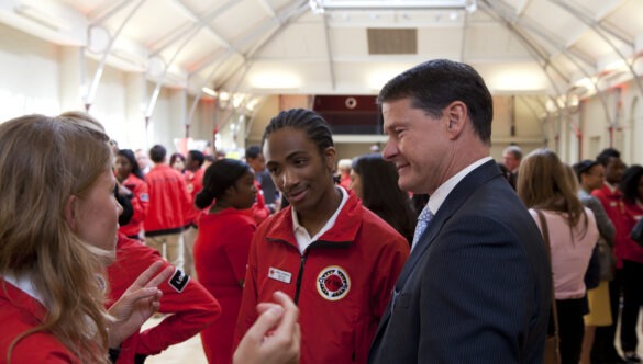 Two volunteer mentors in conversation with Steve Holliday