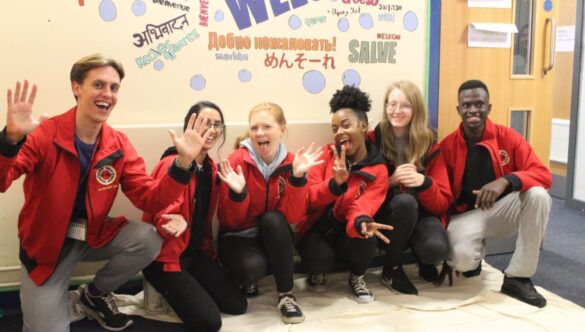 Group of volunteer mentors smiling on the floor of a school