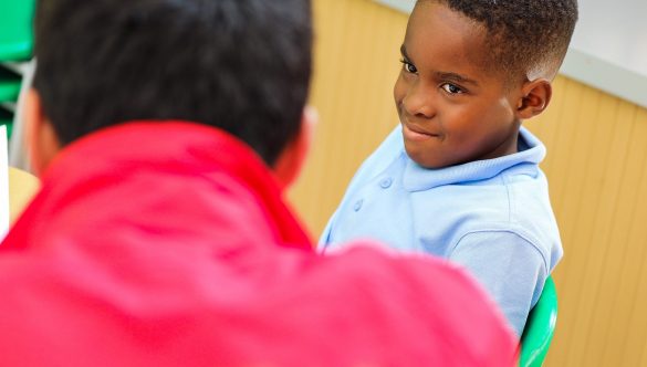 pupil looking at volunteer mentor and smiling